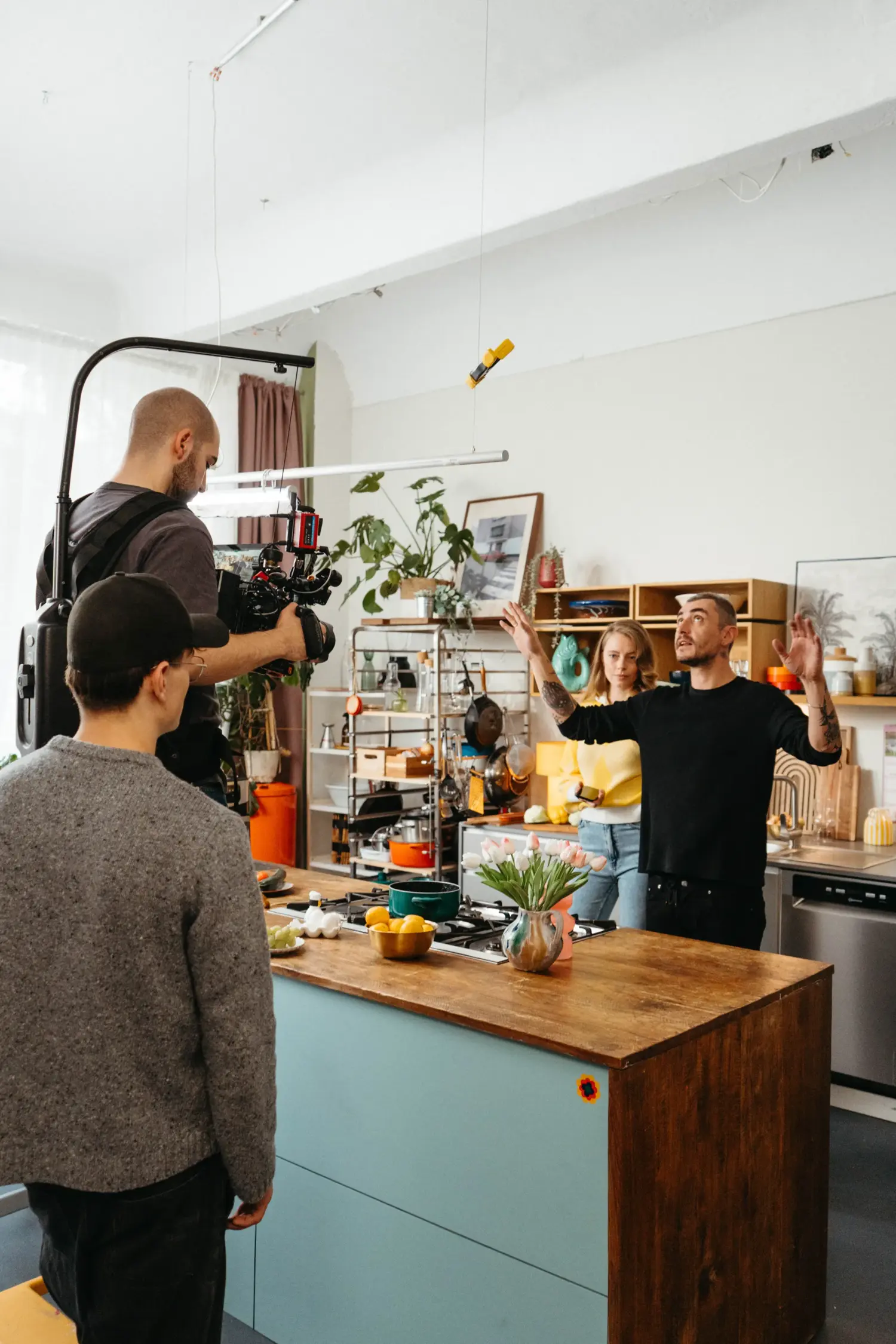 Behind the scenes: DoP Munir Werner filming a cooking scene in a kitchen set using an EasyRig, while director Felix Julian Koch gives instructions.