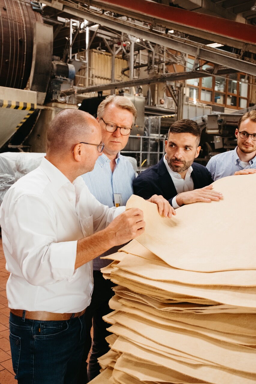 Konstantin Kuhle inspecting the quality of leather hides together with management during a company visit.