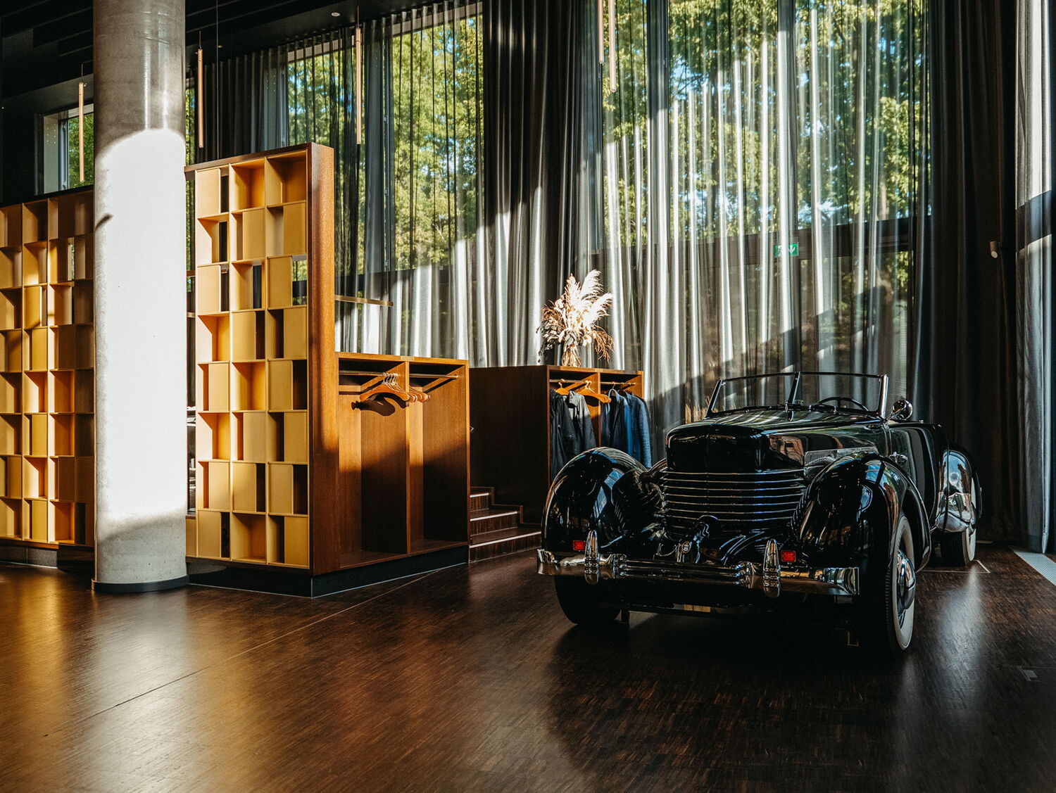 The signature black vintage Cord car stands as the centerpiece in the sun-drenched entrance area of the restaurant.