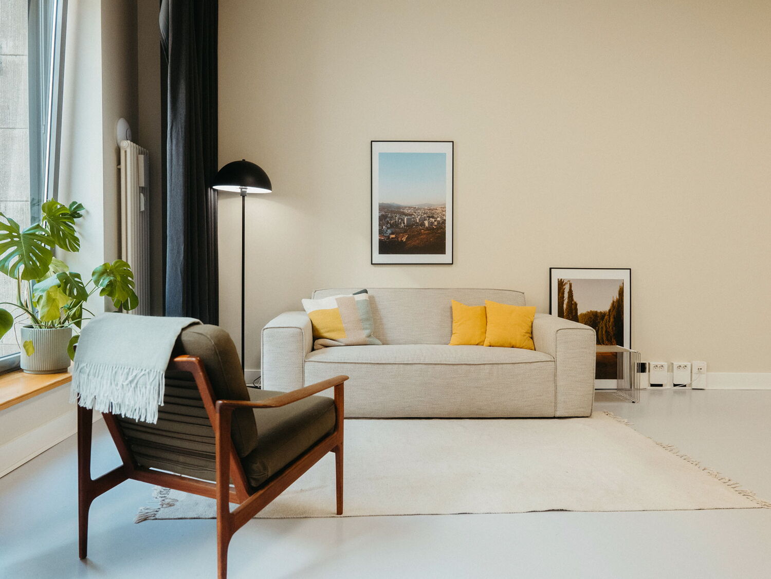 Comfortable client lounge area in the Visionary Berlin photo studio, with a modern sofa, armchair, and stylish floor lamp, perfect for relaxing during a shoot.