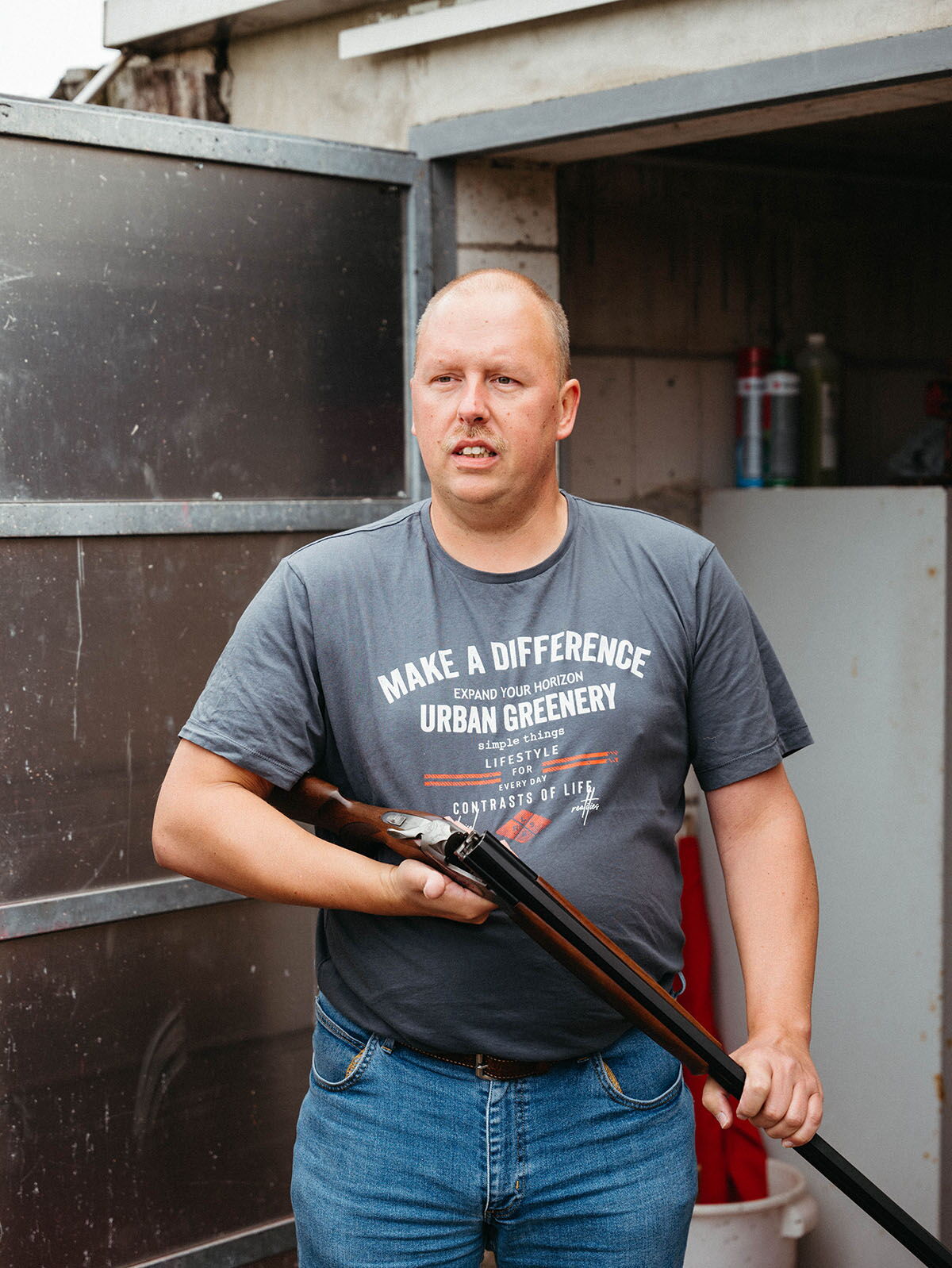 A man holding a shotgun in front of a garage – insights into rural traditions and hobbies in the constituency.