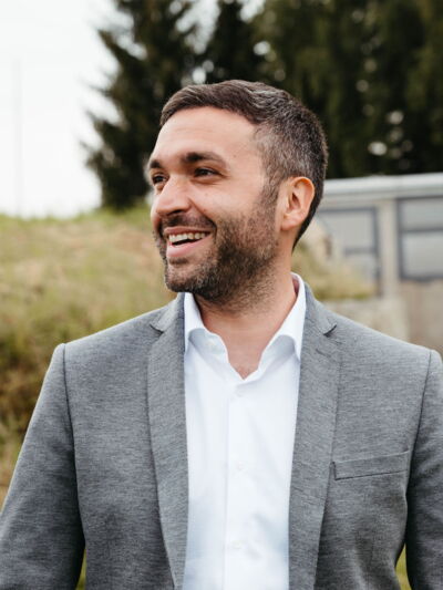 Portrait of Member of Parliament Konstantin Kuhle wearing a grey suit, taken during his summer tour in nature.