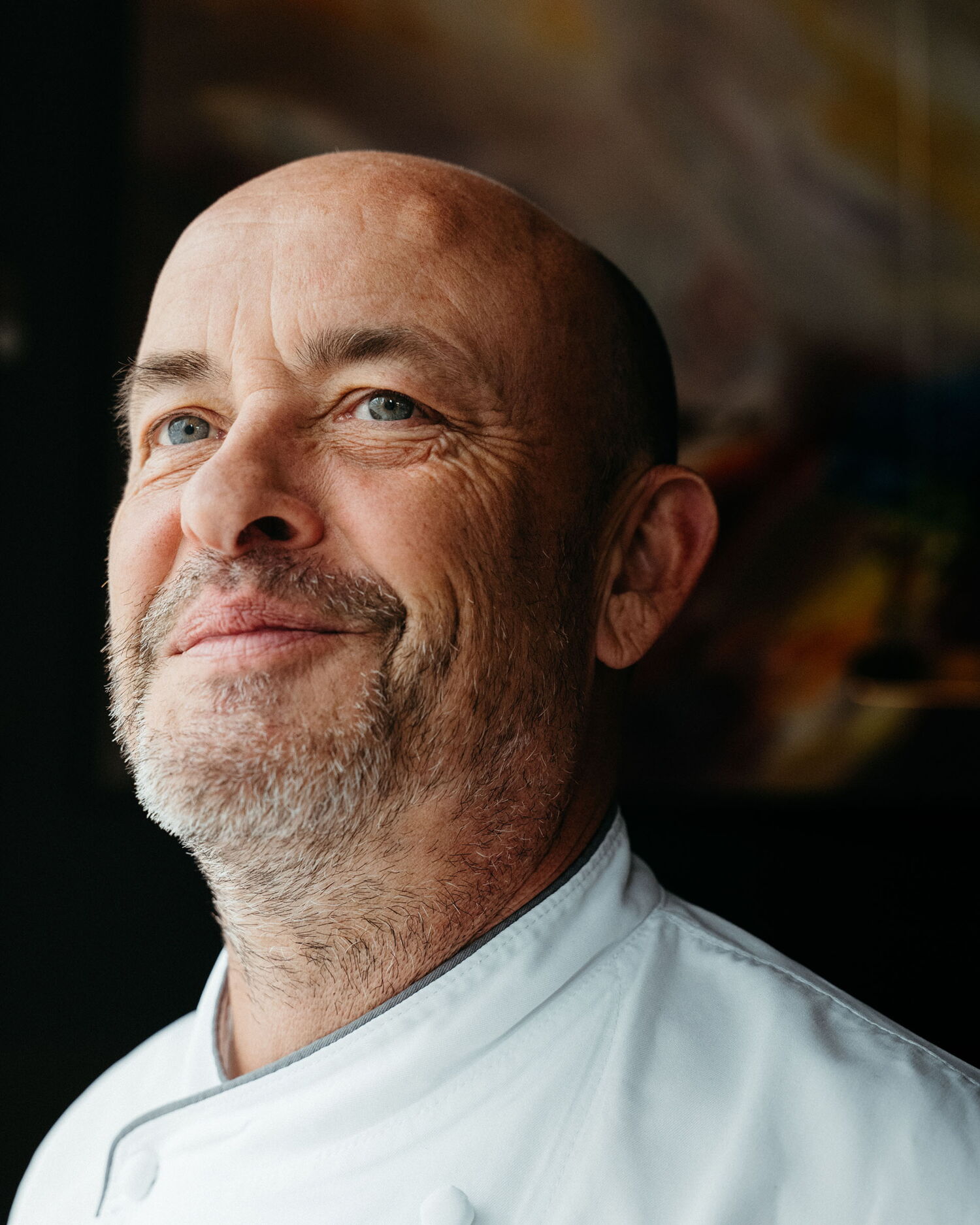Portrait of Thomas Kammeier, Culinary Director of the EUREF-Campus, in a white chef's jacket against a dark background, reflecting the authentic atmosphere of The Cord.