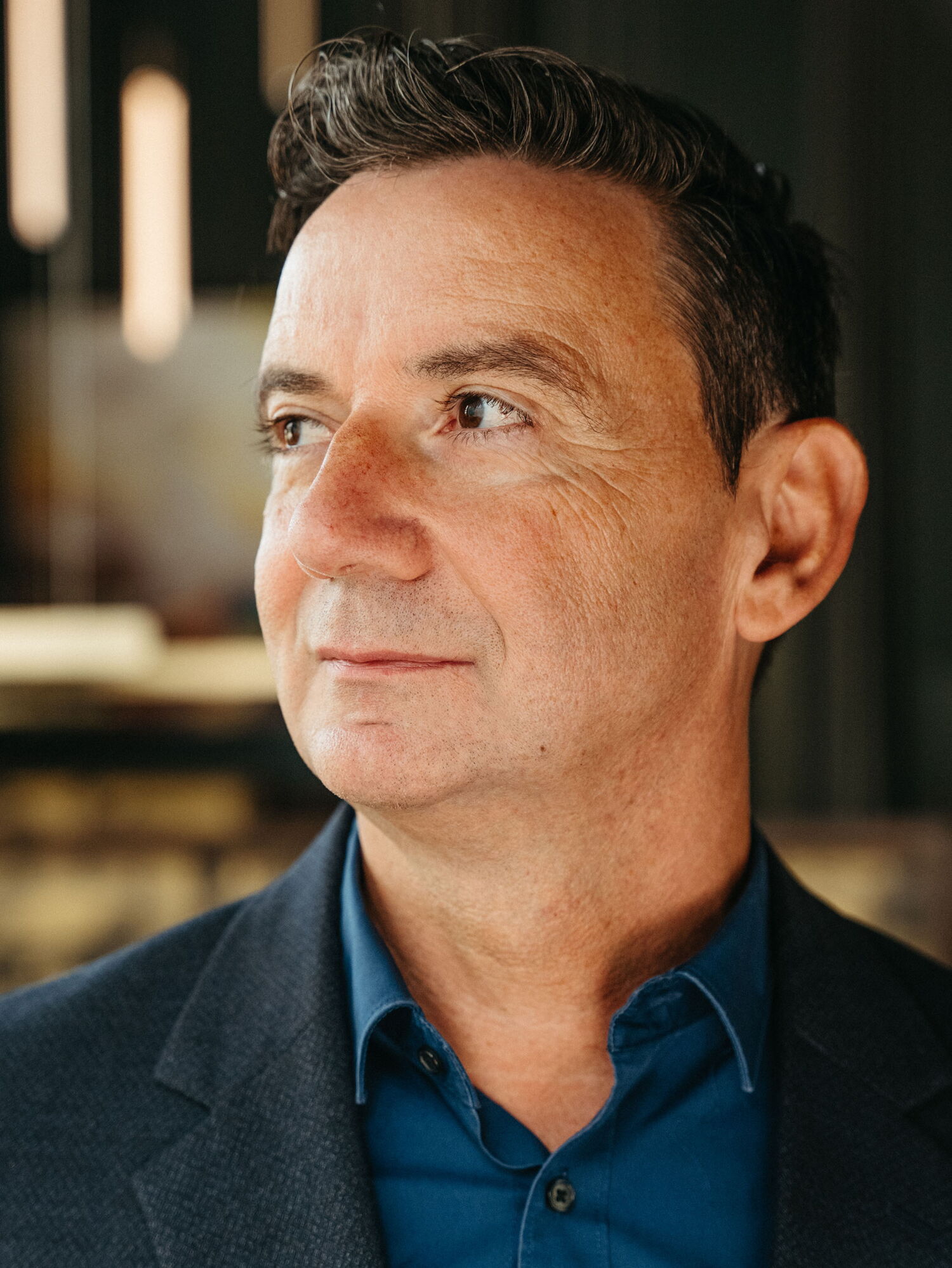 Head of Service of The Cord, wearing a blue shirt and looking into the distance.