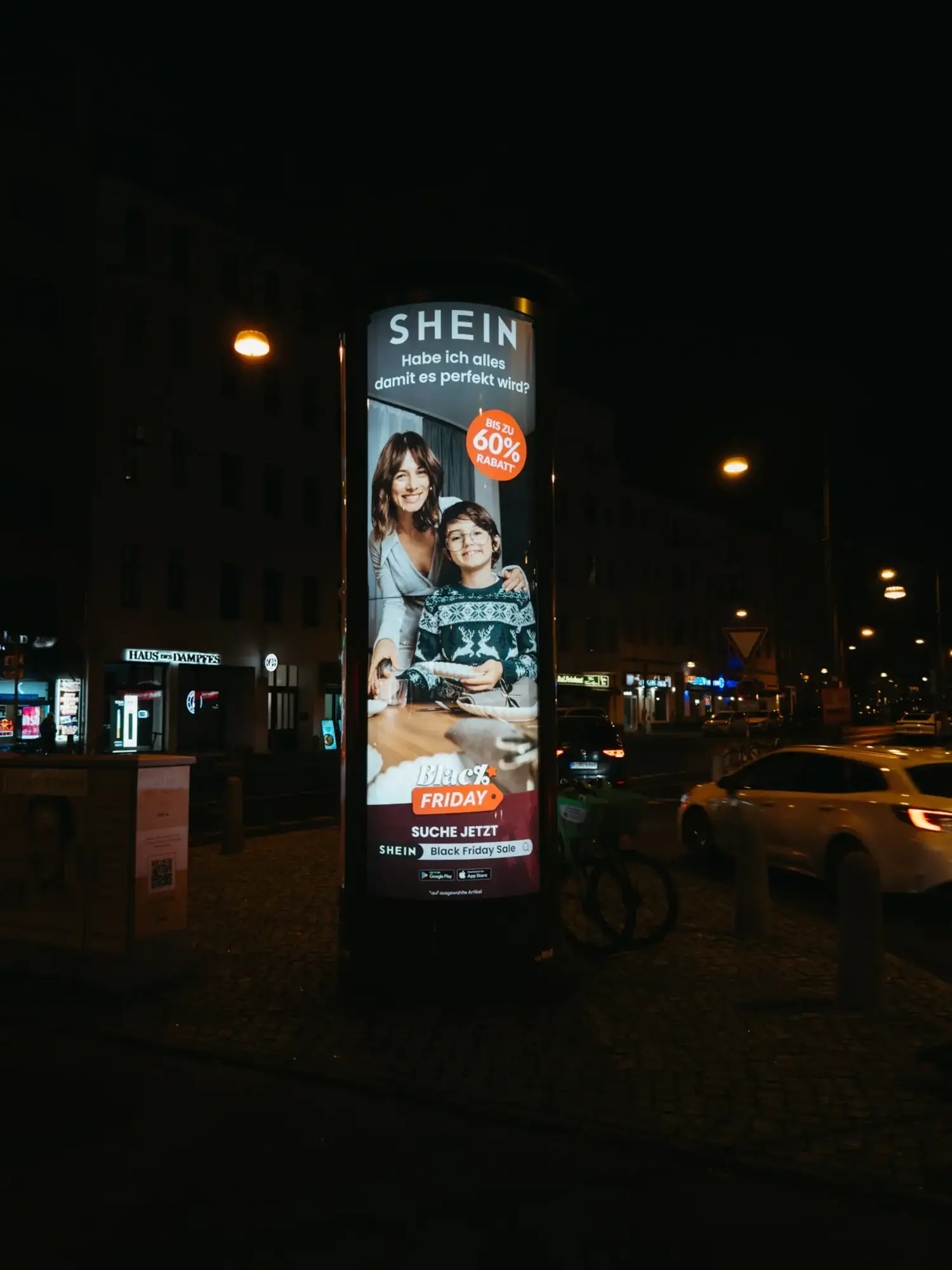 SHEIN advertising poster on a column in a Berlin street. Motif: Mother and son at the dining table.