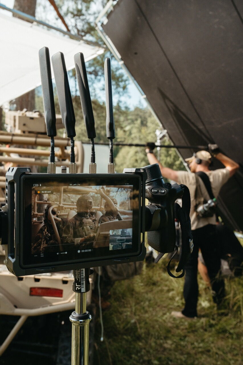 Blick auf den Feldmonitor am Set: Das Display zeigt Soldaten im Fahrzeug, im Vordergrund die Antennen der drahtlosen Videoübertragung.