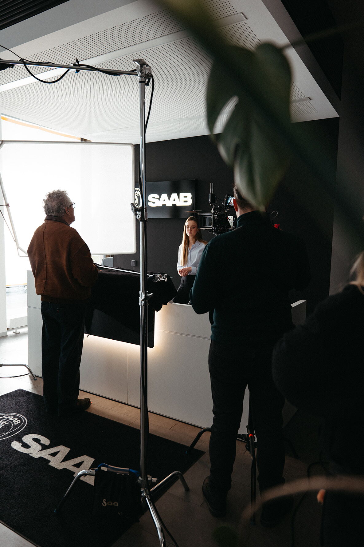 Behind the Scenes: The camera crew filming the dialogue scene at the reception desk, lit by a large softbox.