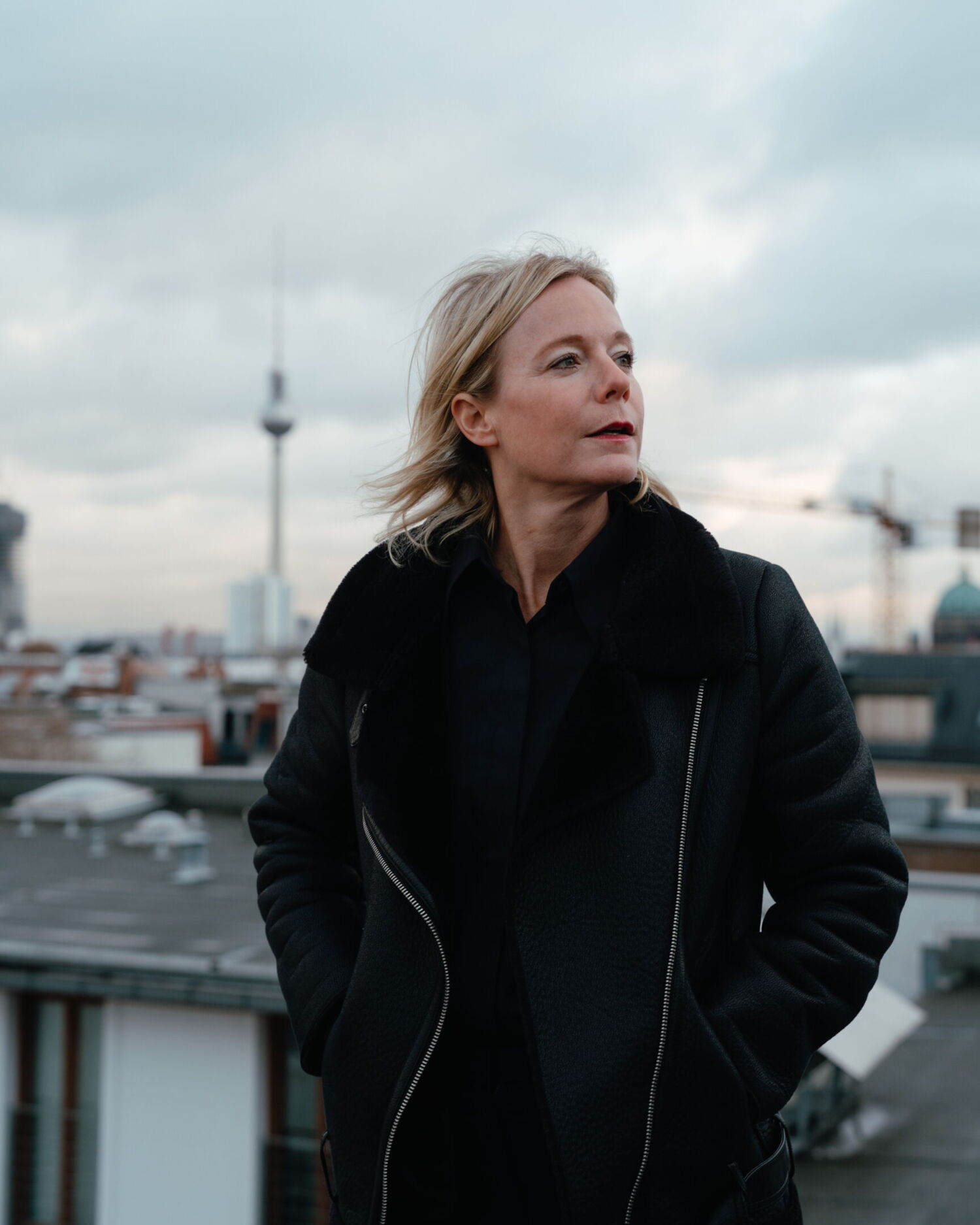 Portrait of Nina Pütz in a black jacket with the Berlin TV Tower in the background. Personal branding photography for the CEO of parfumdreams and Niche Beauty by Munir Werner.