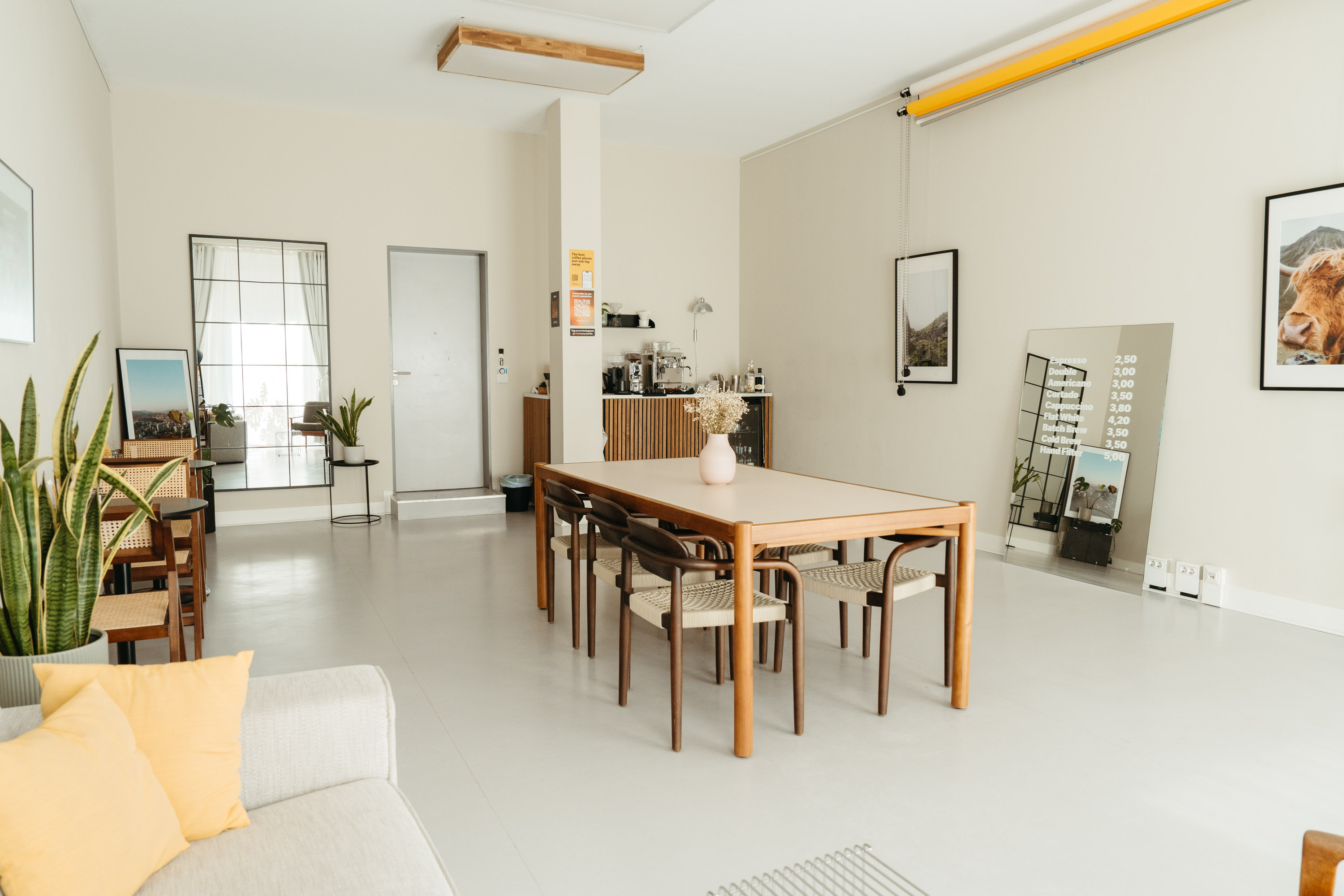 The spacious and versatile area of the Visionary Berlin und Munir Werner studio, featuring a large wooden dining table that can be used for team meetings, lunch breaks, or as a shooting set.