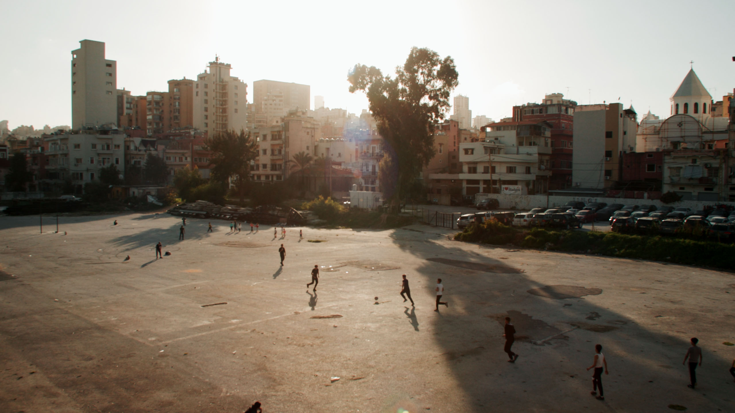Kinder spielen Fußball auf einem staubigen Platz in Beirut, Libanon – ein atmosphärischer Establishing Shot der Dokumentation.