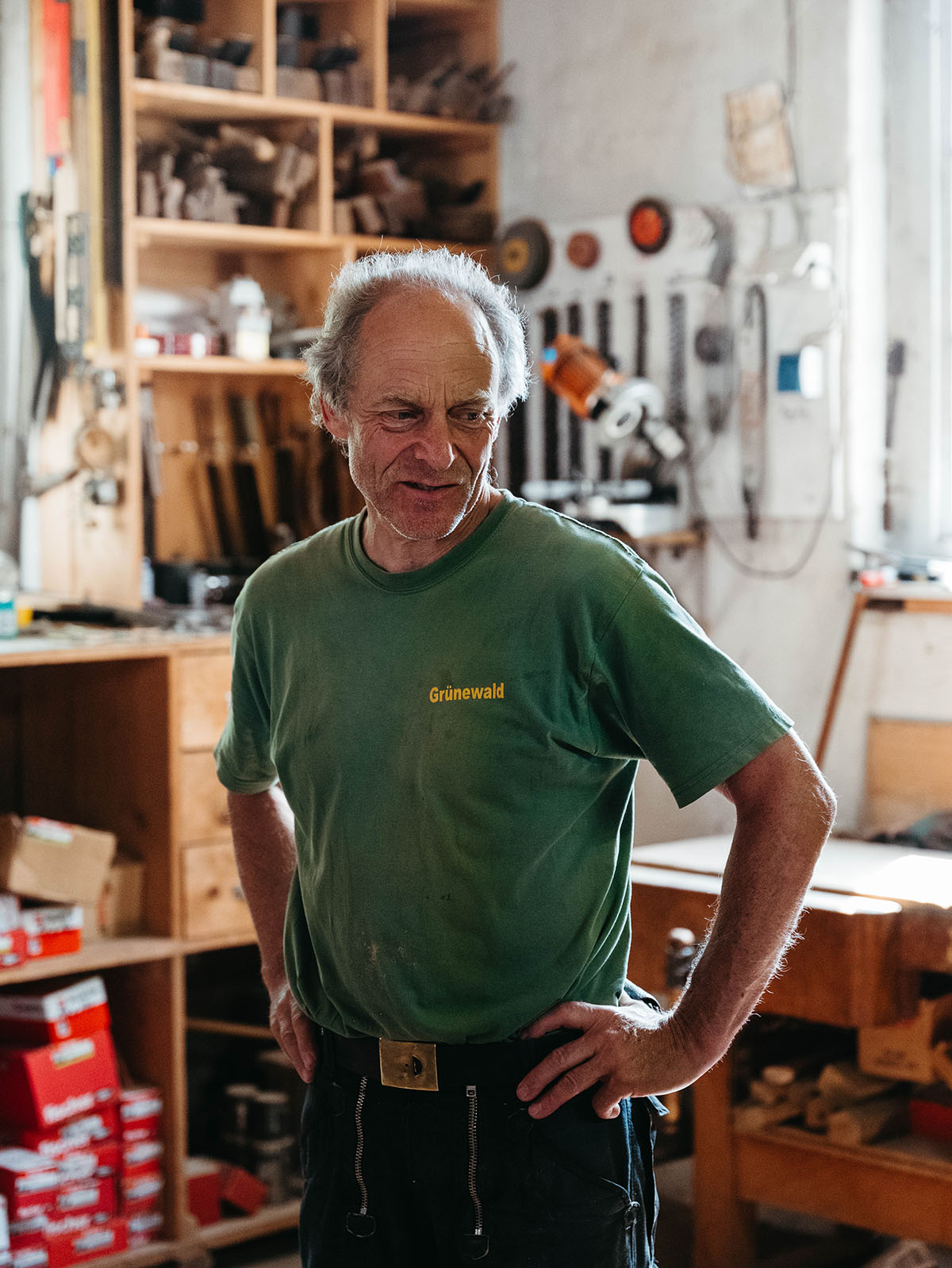 Authentic portrait of a master carpenter in workwear inside his workshop.