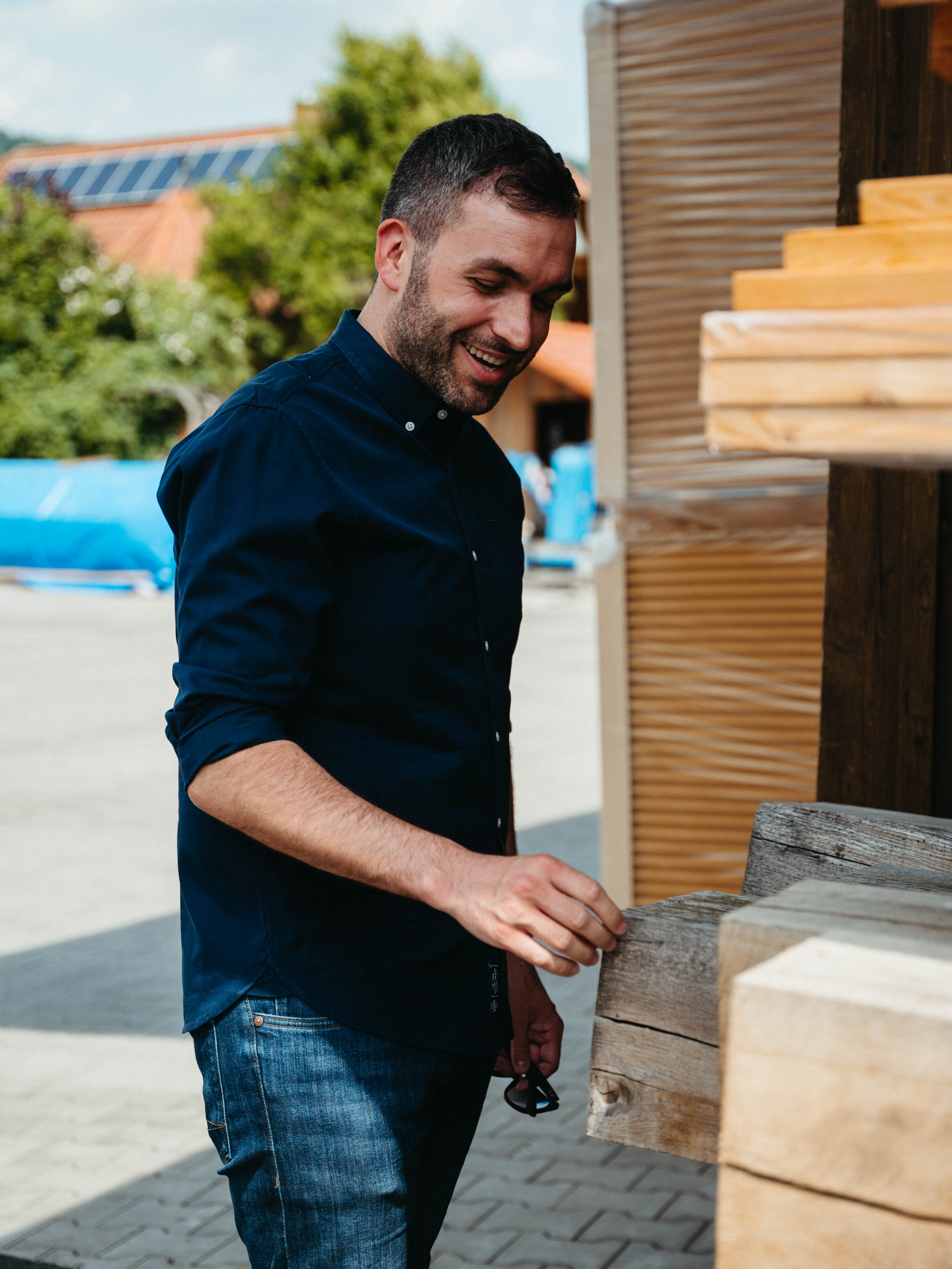 Konstantin Kuhle inspecting the quality of timber beams with interest in the carpentry yard.