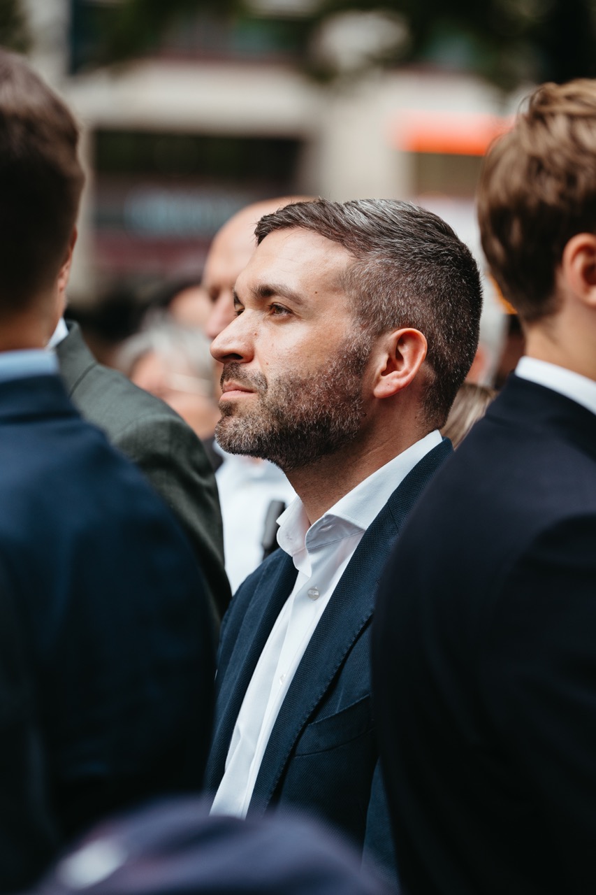 Nahaufnahme von Konstantin Kuhle im Profil, der inmitten einer Menschenmenge auf einer Veranstaltung steht.